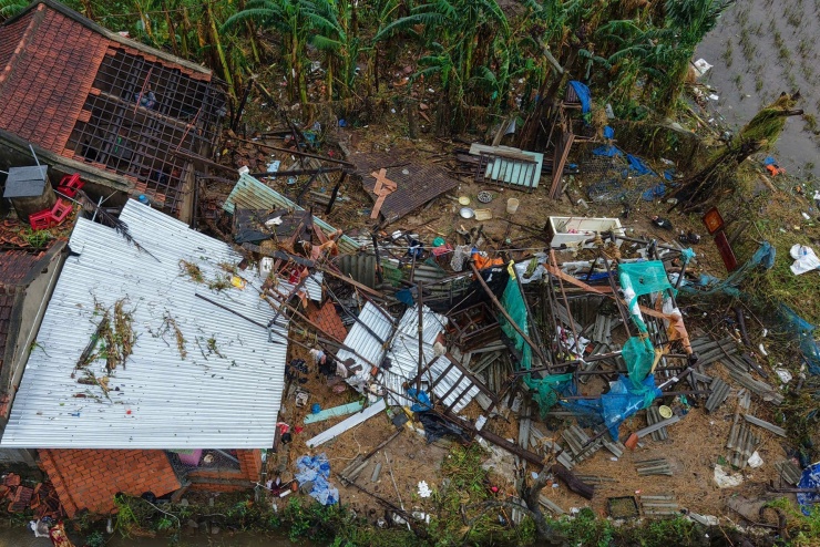 Nhiều mảng ngói và tường nhà của chị Liên bị lũ cuốn sập, chỉ còn một số thành dầm. Kế bên, những căn nhà hàng xóm chỉ còn là đống đổ nát.