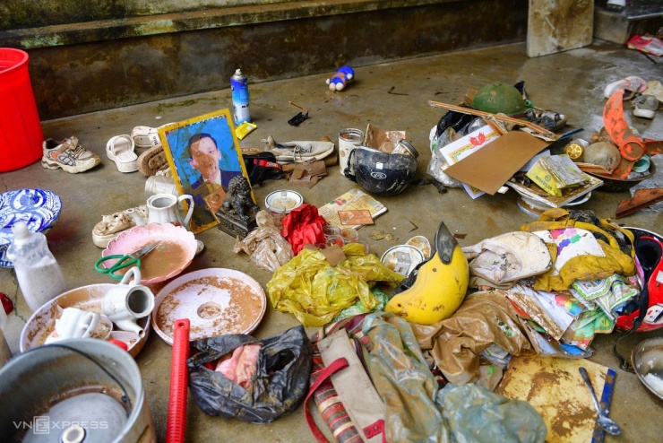 Những vật dụng được chị Phượng nhặt nhạnh sau trận lũ, trong đó có di ảnh của người thân lấm lem bùn đất.