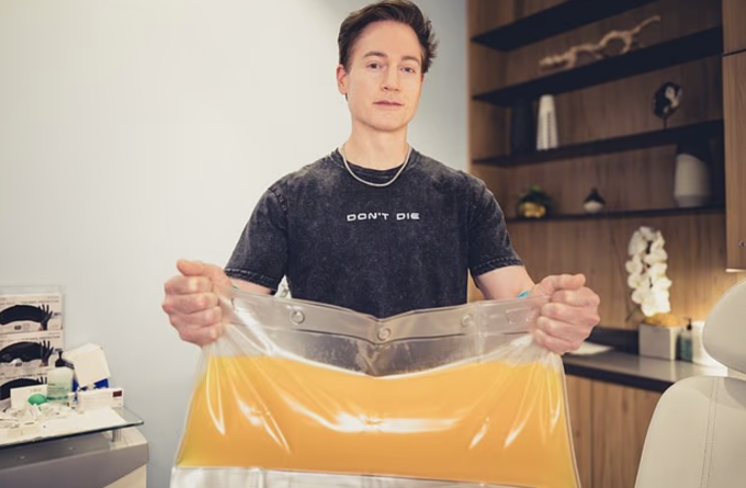 Tỷ phú Bryan Johnson cầm trên tay túi huyết tương được lọc ra khỏi cơ thể. Ảnh: Mail