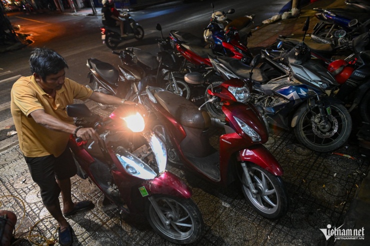 Anh Nguyễn Thành Nhân làm việc tới tối muộn tại tiệm sửa xe trên đường Nguyễn Trãi, phường Nha Trang.