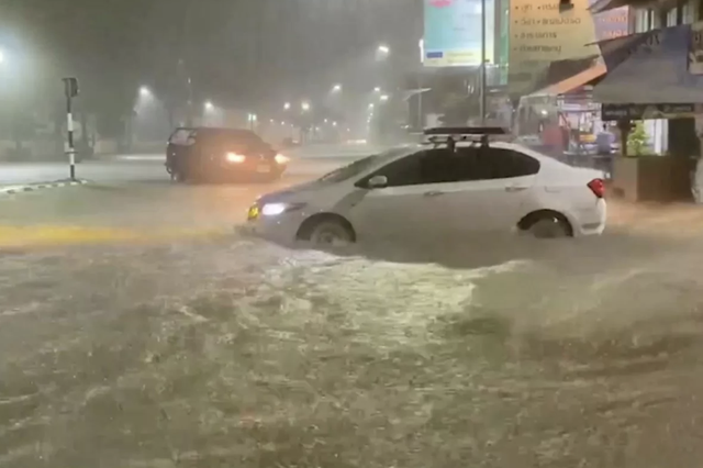 Xe di chuyển qua dòng nước lũ dâng cao trên một con đường ở Hat Yai, tỉnh Songkhla. Ảnh: Bangkok Post