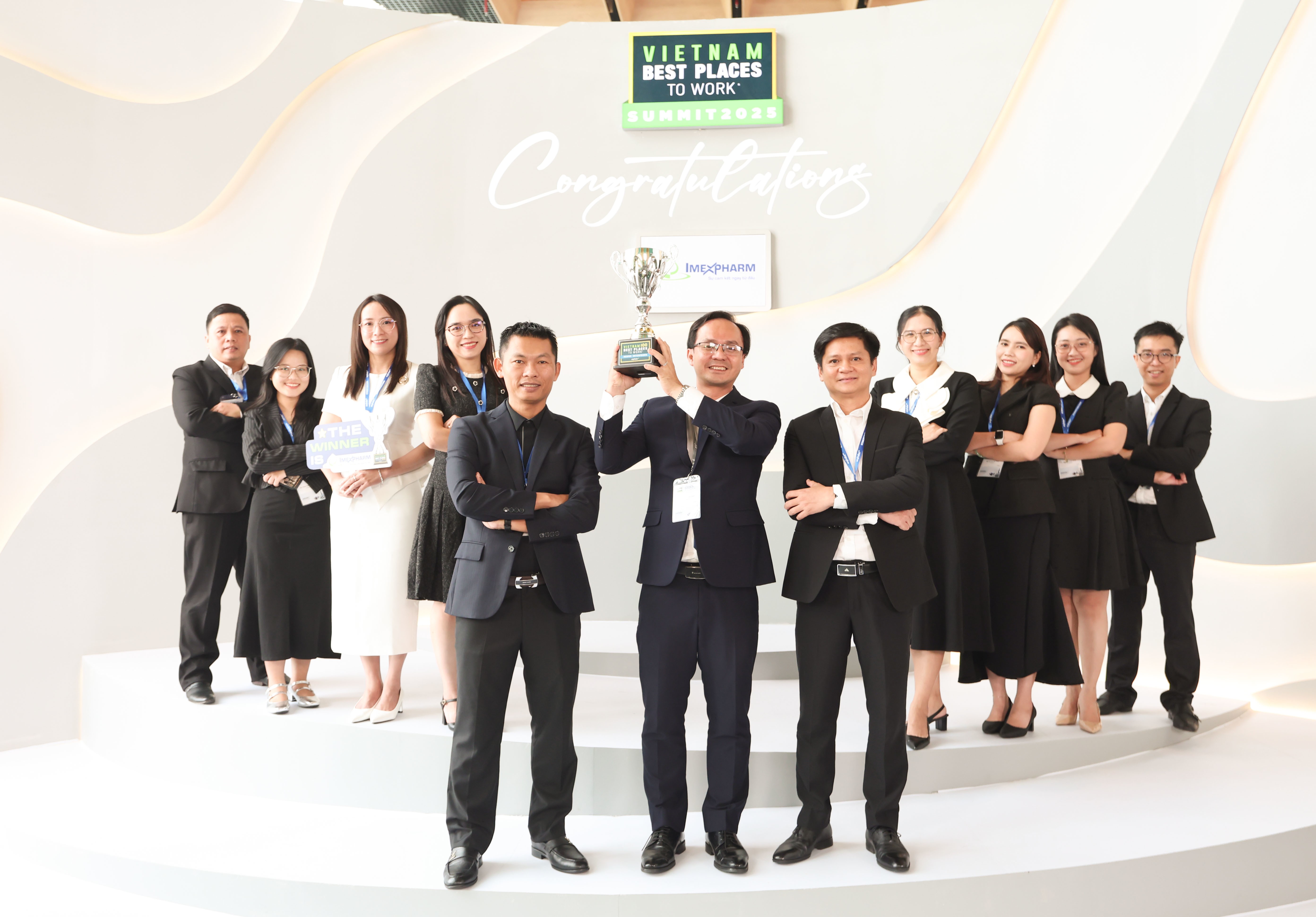 Tiến sĩ Nguyễn Vĩnh Luận, Giám Đốc HR của Imexpharm, giơ cao cúp Anphabe vinh danh Imexpharm là Nơi làm việc tốt nhất Việt Nam 2025. Ảnh: Imexpharm.