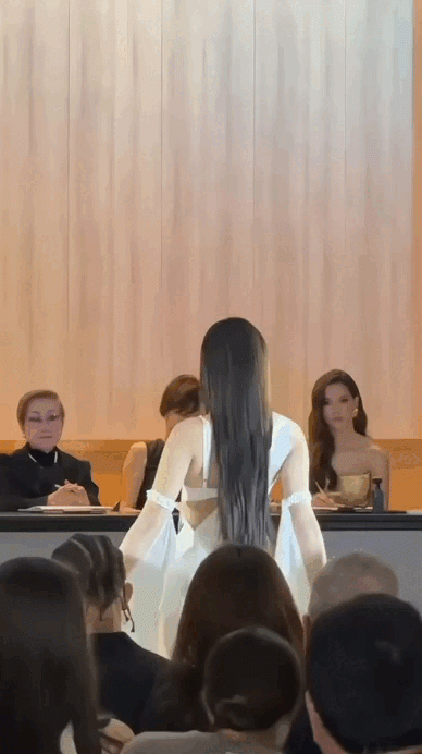 Kiều Duy diện mẫu áo tắm 2 mảnh, màu trắng kèm tà lụa phía sau tạo sự nữ tính khi di chuyển và trình diễn.