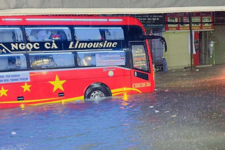 Xe khách vất vả di chuyển qua đoạn ngập. Ảnh: A.X