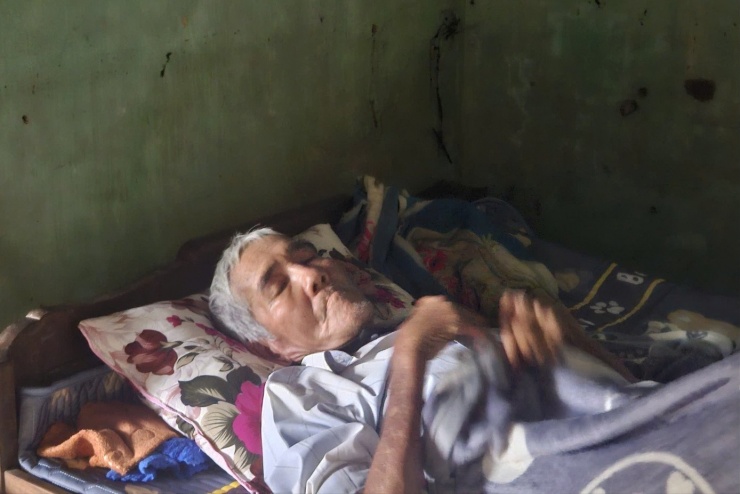 Ông Hưng nằm co ro trên chiếc giường còn đẫm nước.