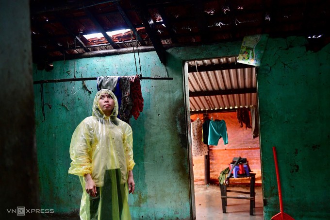 Chị Nguyễn Thị Phương trong căn nhà nơi ba mẹ con kẹt từ tối 19/11 khi nước dâng cao. Ảnh: Đình Văn