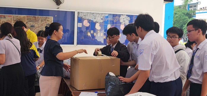 Học sinh cùng thầy, cô giáo gói ghém các thùng hàng để hỗ trợ đồng bào