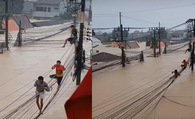 Người dân mạo hiểm đu bám các sợi cáp treo lơ lửng giữa không trung. Ảnh: Thai PBS