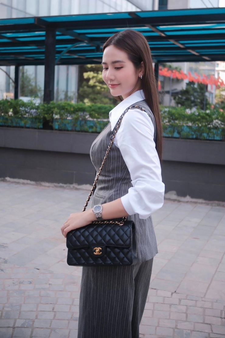 Mỹ nhân còn thường đeo mẫu Chanel Classic Flap Bag - dòng túi kinh điển luôn được tín đồ thời trang săn đón. Với tông màu đen phối dây xích, chiếc túi phù hợp với những bộ cánh công sở trung tính, đứng dáng của Phan Minh Huyền.