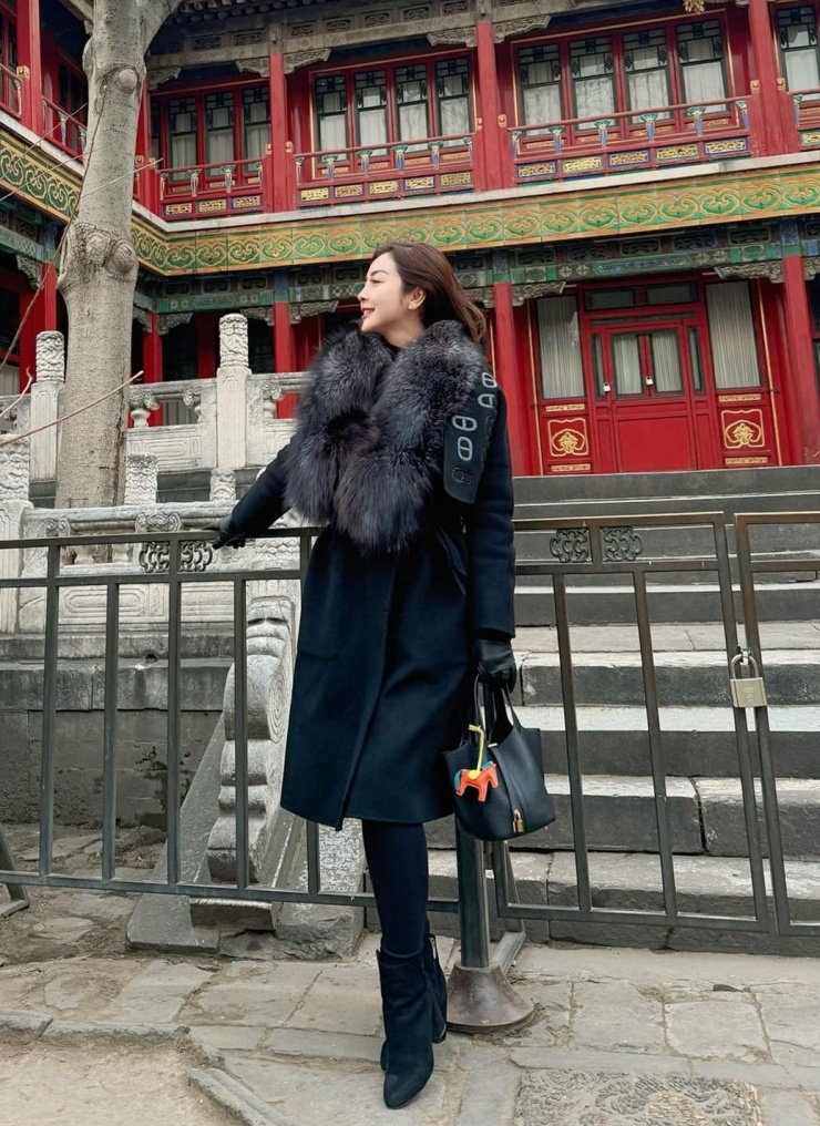 Trong chuyến sang Bắc Kinh, Trung Quốc, Jennifer Phạm diện áo khoác dạ viền cổ lông với quần legging và bốt cổ thấp.