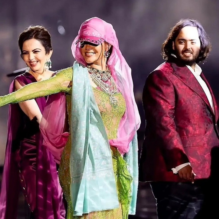 Tháng 3/2024, Rihanna gây bất ngờ khi góp mặt trong tiệc của gia đình Ambani tại thành phố Jamnagar (Ấn Độ). Theo Independent, cô nhận gần bảy triệu USD cho 40 phút biểu diễn. Ca sĩ đi chân trần trên sân khấu, thể hiện các ca khúc Consideration, Birthday Cake, Pose và nhảy múa cùng gia đình cô dâu chú rể. Từ trái qua: Vợ ông Mukesh - bà Nita, Rihanna và Anant Ambani. Ảnh: ANI