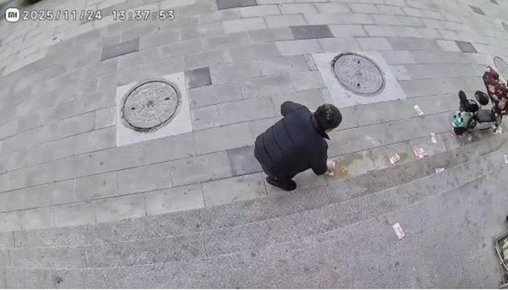  Anh Kim được mọi người hỗ trợ nhặt lại số tiền bị rơi trên đường. Ảnh: Ifeng