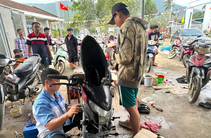 Nhóm của anh Đức đang sửa xe cho người dân thôn Mỹ Điền, Hòa Thịnh, sáng 26/11. Ảnh: Nhân vật cung cấp