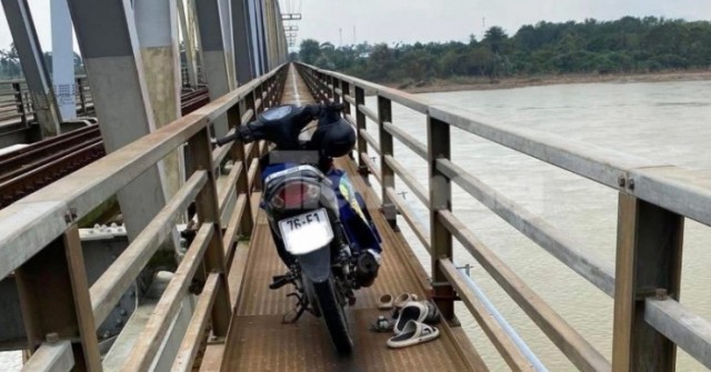 Người đàn ông ôm hai cháu nhỏ nhảy cầu, một chá...