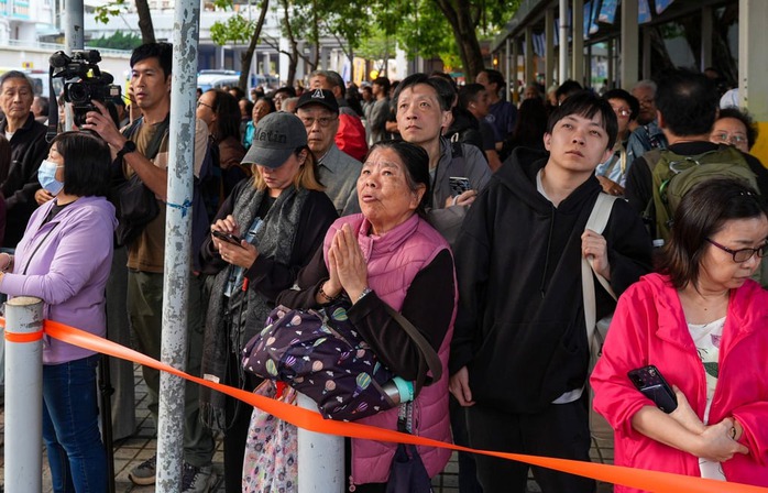 Nhiều người cầu nguyện cho người thân vẫn đang mắc kẹt trong toà nhà bốc cháy. Ảnh: Eugene Lee