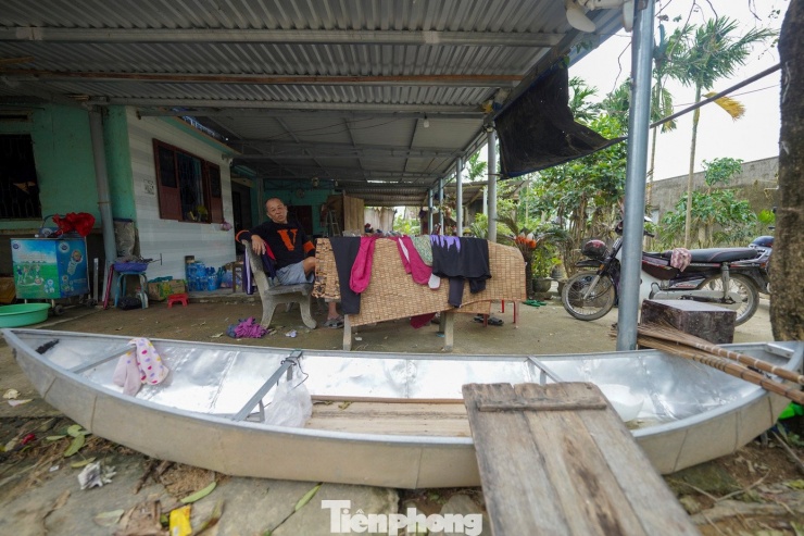 Ông ba Thành ngồi bên chiếc xuồng huyền thoại.