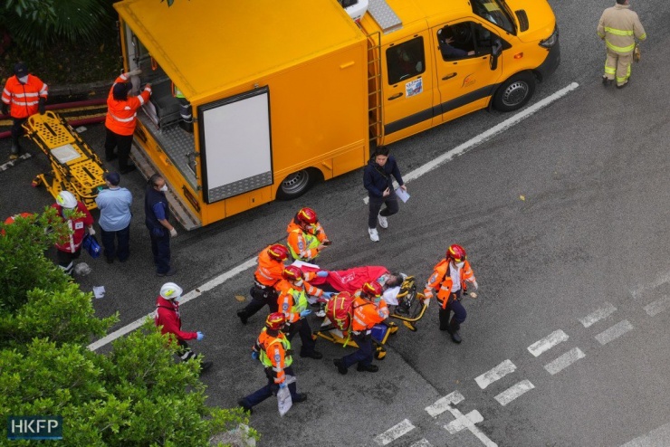 Lực lượng cứu hỏa đưa người bị thương đi cấp cứu. Ảnh: HKFP
