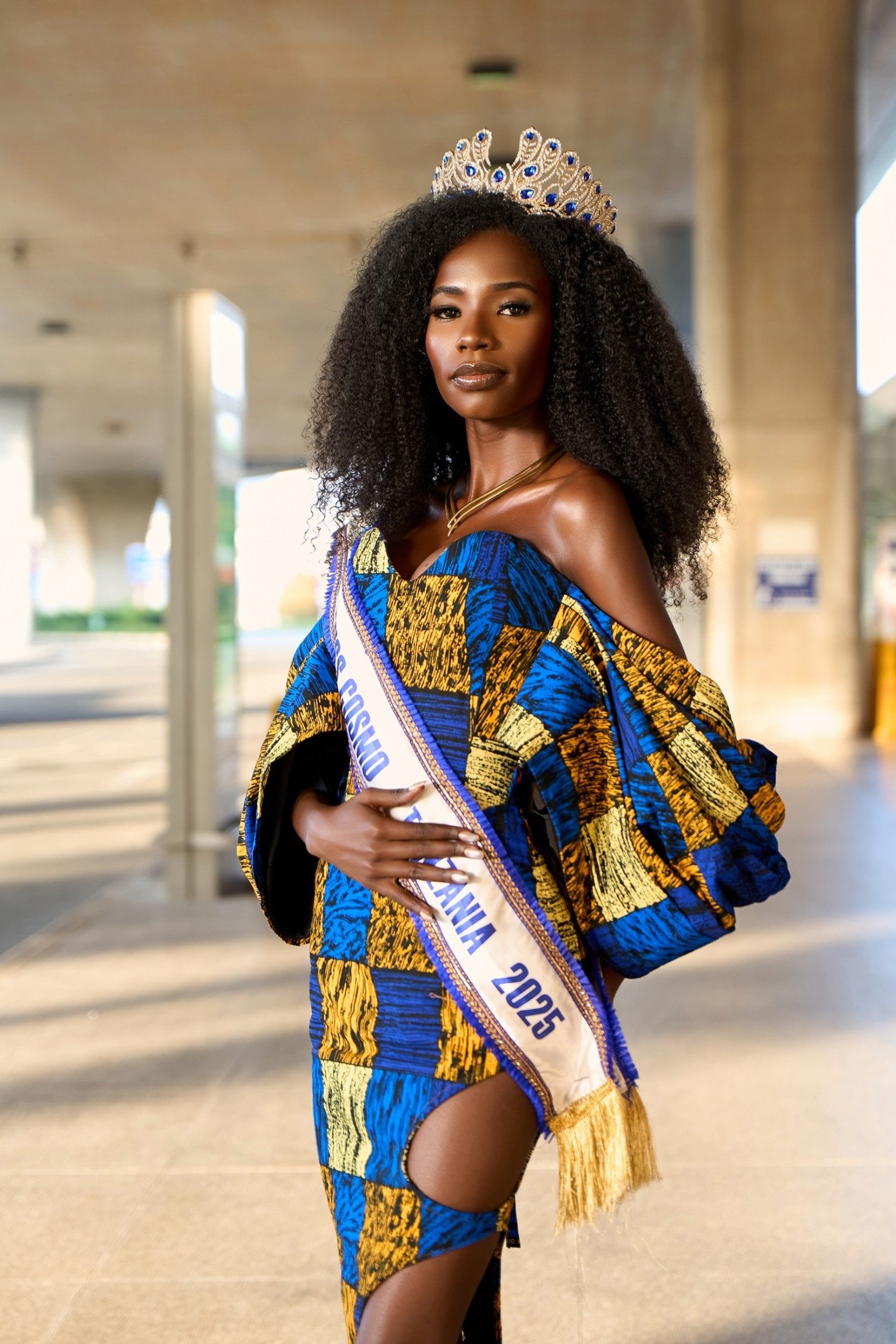 Là thí sinh có mặt sớm nhất, Miss Cosmo Tanzania 2025 Jesca Micca gây chú ý với thần thái tự tin trong bộ trang phục truyền thống kutenge màu xanh small color.