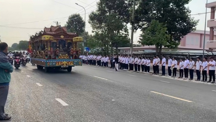 Học sinh cùng thầy cô giáo Trường THPT Nguyễn Bỉnh Khiêm đứng hai bên đường tiễn biệt trước linh cữu người thầy. Ảnh cắt từ clip