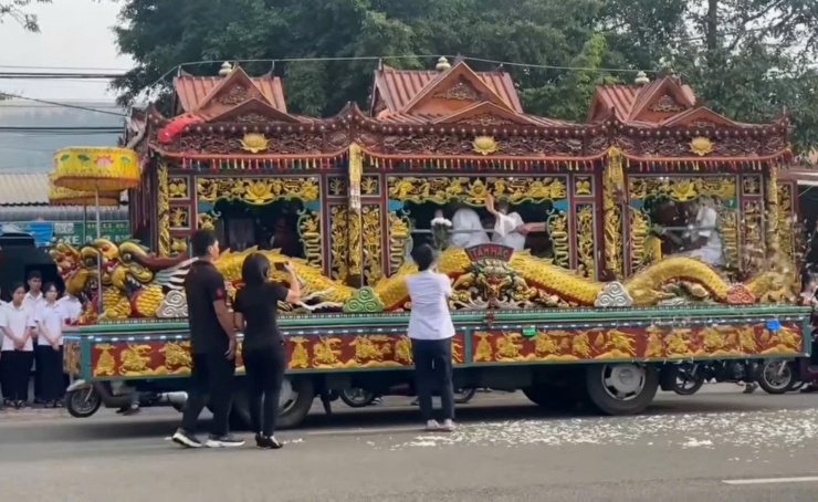 Một em học sinh dâng lên xe linh cữu của thầy bó hoa trắng như lời tri ân sâu sắc. Ảnh cắt từ clip