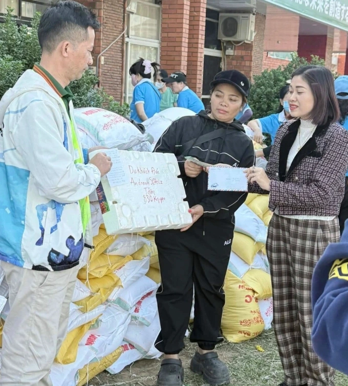 Chị Thanh Hải (ngoài cùng bên phải) trao 830 kg gạo của khách Đức cho đội cứu trợ. Ảnh: NVCC