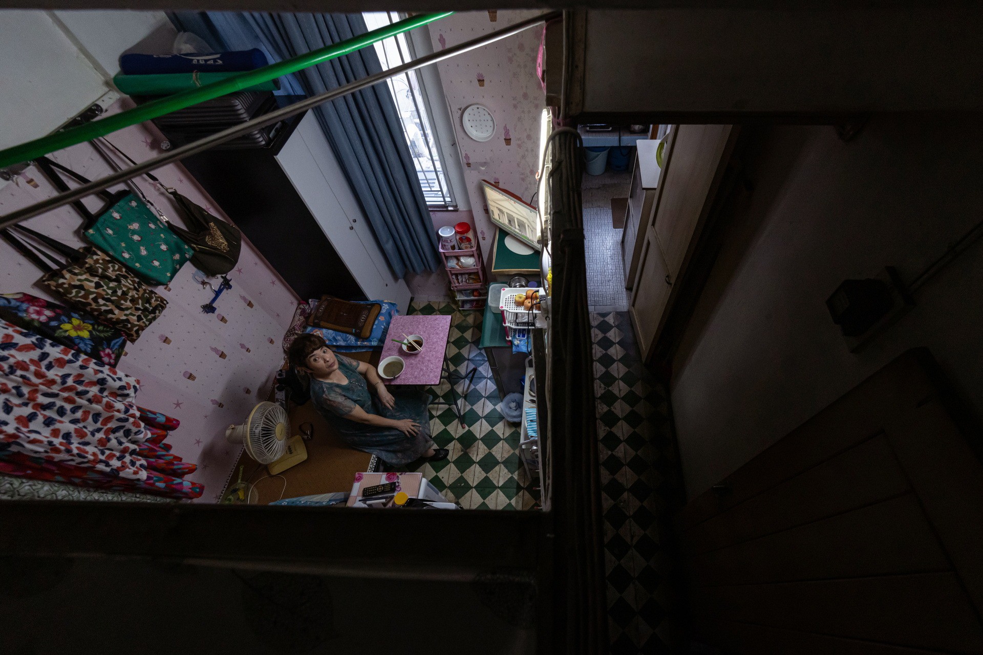 Bà Xiao Bo ngồi trong căn hộ chia nhỏ ở Hong Kong. Ảnh: Reuters