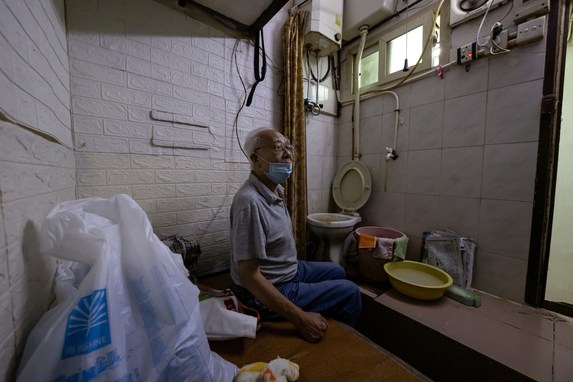 Ông Wong và căn hộ siêu nhỏ với nhà vệ sinh cạnh ngay giường nằm. Ảnh: Reuters