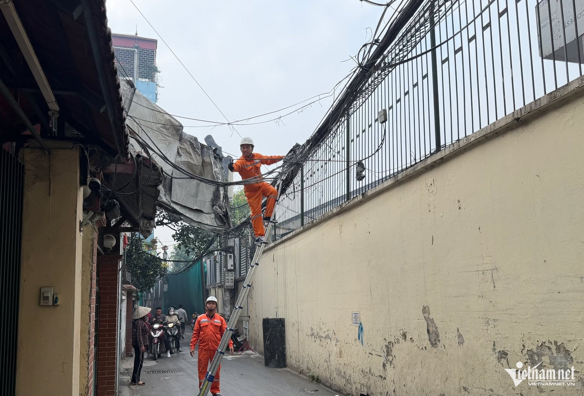 Một mảnh tôn bay sang ngõ bên cạnh, nhân viên của Công ty Điện lực đang khắc phục dây bị đứt