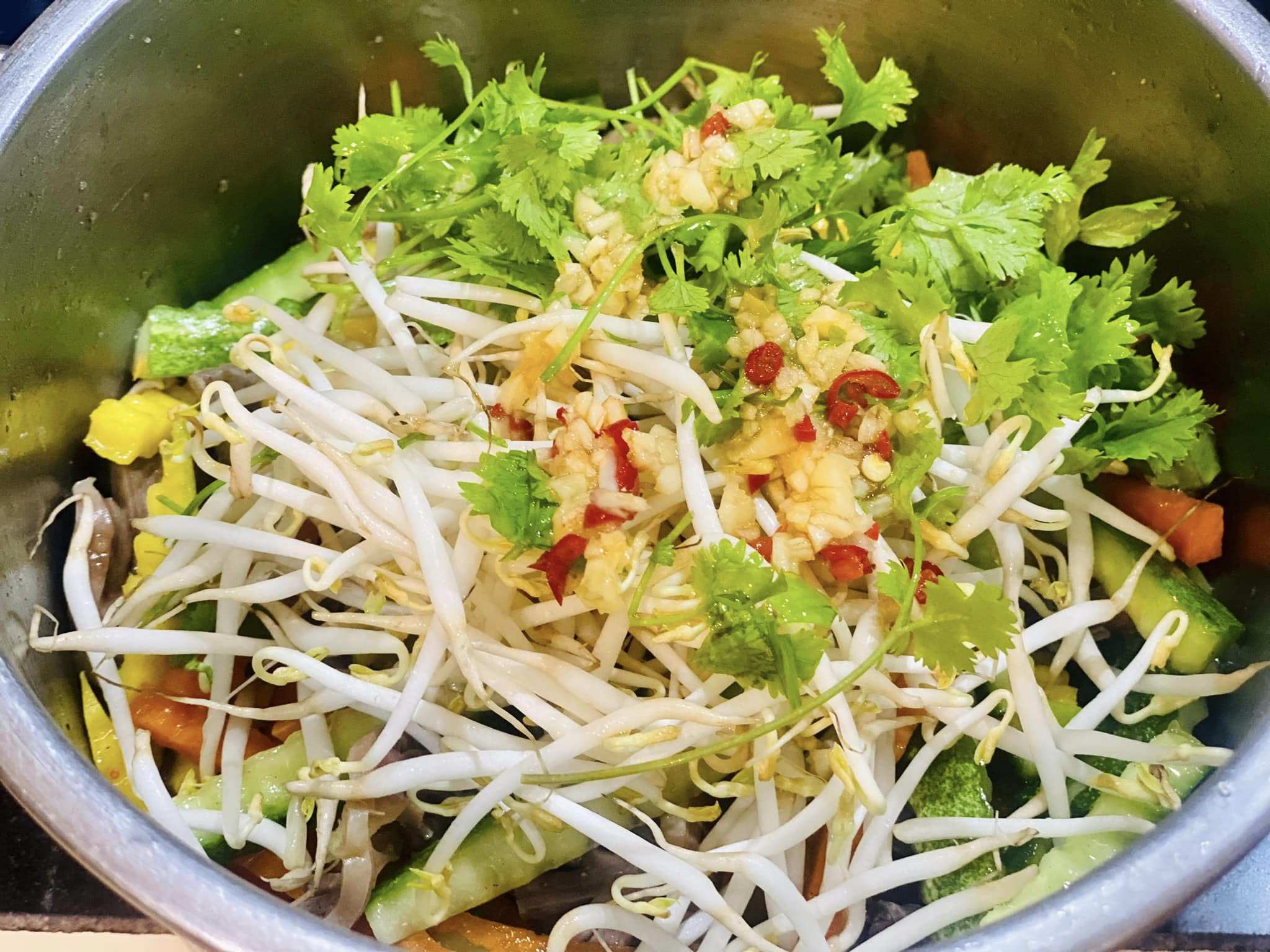 Chắt bỏ phần nước rồi tiếp tục nêm 1 thìa nước mắm, 1 thìa đường, 1 thìa nước cốt chanh, tỏi, ớt giã nhuyễn, 1 thìa vừng rang, rau mùi và giá đỗ. Trộn đều và nếm lại để điều chỉnh độ chua ngọt theo mong muốn.