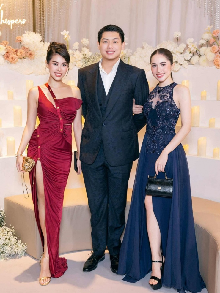 Nàng fashionista chụp hình cùng em trai Hiếu Nguyễn và 'em dâu tương lai' Marie Trâm Anh. Chiếc đầm màu đỏ rượu vang với thiết kế cắt xẻ táo bạo giúp Tiên Nguyễn trông nổi bật.