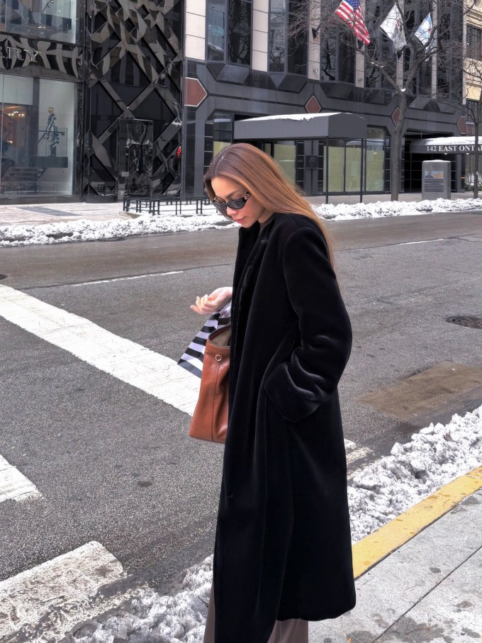 Hồ Ngọc Hà phối áo măng-tô chất liệu nhung với quần âu tối màu và hoàn thiện phong cách bằng kính râm, túi xách hàng hiệu cỡ lớn.