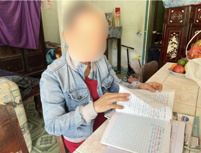 Bà N.T.H (mẹ ruột nữ sinh) đau lòng khi lật từng trang tập của con gái