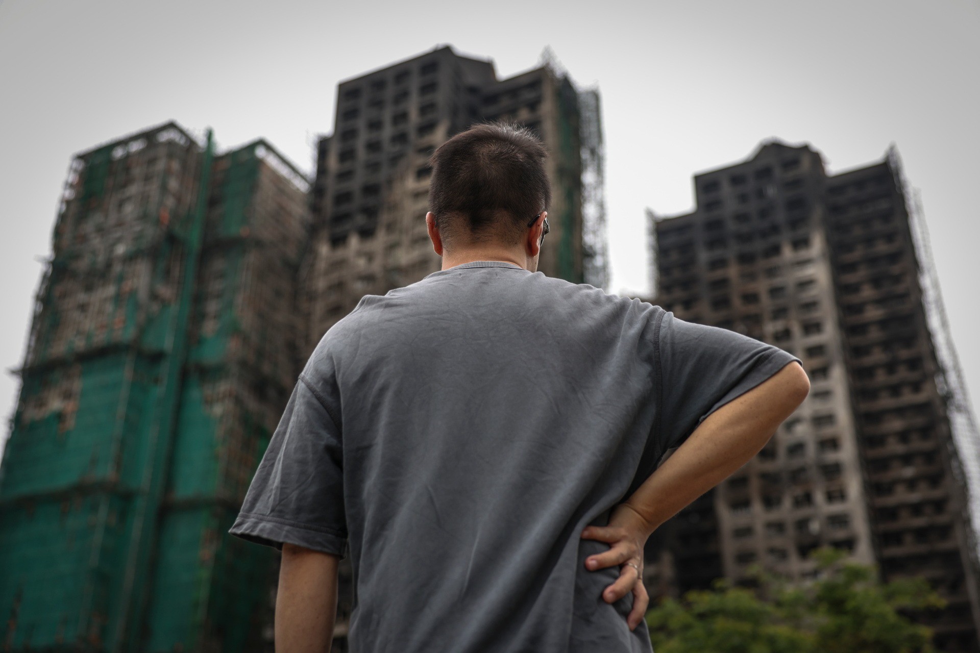 J. Wong đừng nhìn về phía các tòa nhà bị cháy, nơi mẹ anh vẫn chưa được tìm thấy. Ảnh: Reuters