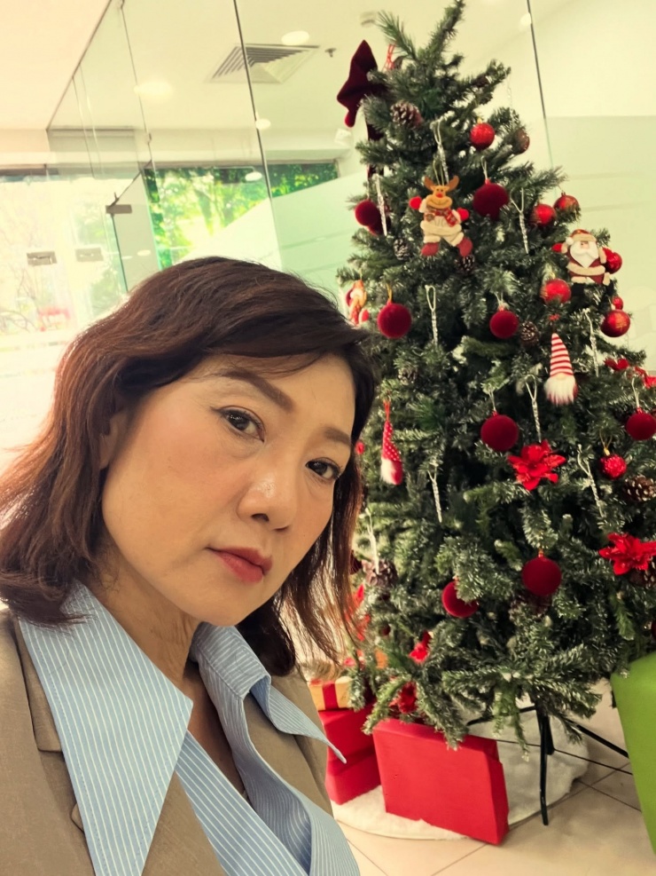 NSND Mỹ Uyên tạo dáng bên cây thông, nói "mặt buồn nhưng vui trong lòng".