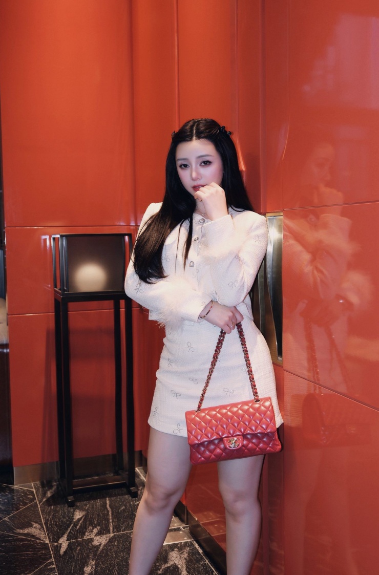 Túi xách màu đỏ nổi bật là điểm nhấn của tổng thể outfit Quỳnh Kool lựa chọn.