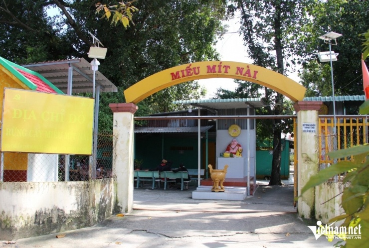 Cổng vào miếu Mít Nài với một bên là tấm bảng ghi dòng chữ "địa chỉ đỏ" đã phai màu. Ảnh: Hà Nguyễn