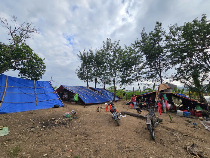 Cách đó không xa, vợ chồng chị Nay H'Ri cùng 4 con nhỏ phải dựng lều ở tạm trong nhiều ngày chờ nước rút