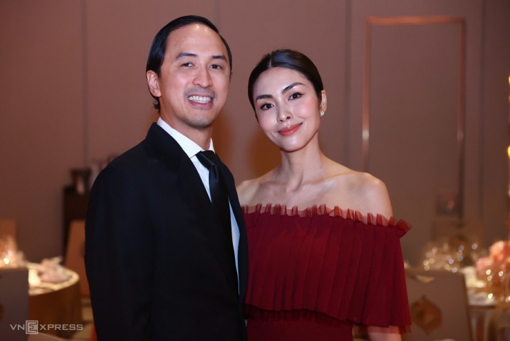 Tăng Thanh Hà diện váy màu đỏ trễ vai, tóc búi gọn, sánh vai chồng - doanh nhân Louis Nguyễn - trong đám cưới em gái.