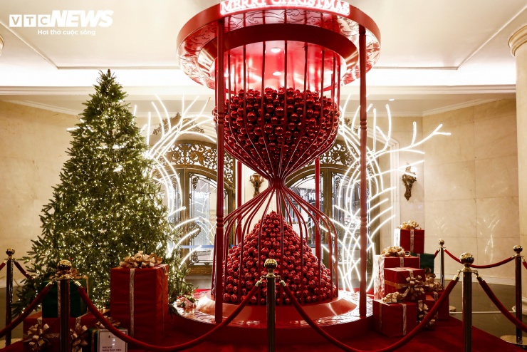 Tại cổng chính, một tiểu cảnh cầu kỳ được dựng lên, nổi bật với chiếc đồng hồ cát chứa hàng nghìn quả châu đỏ bắt mắt.