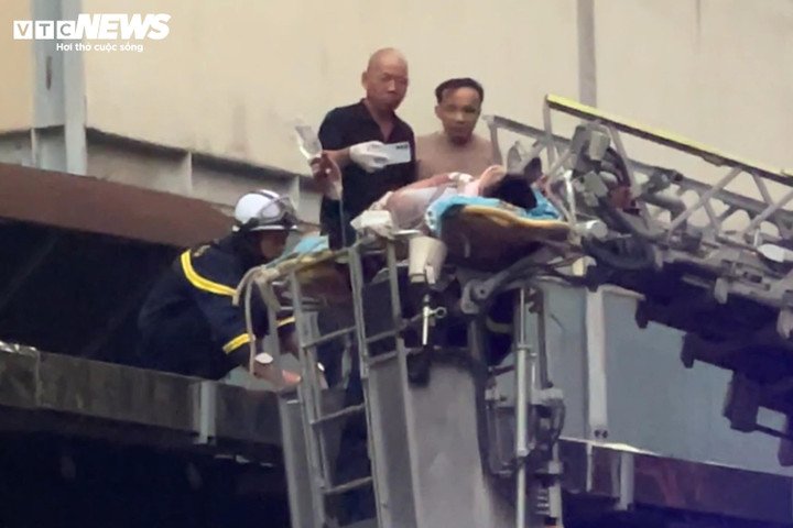 Lực lượng chức năng dùng xe thang đưa nạn nhân ra khỏi khu vực nguy hiểm. (Ảnh: Minh Đức)