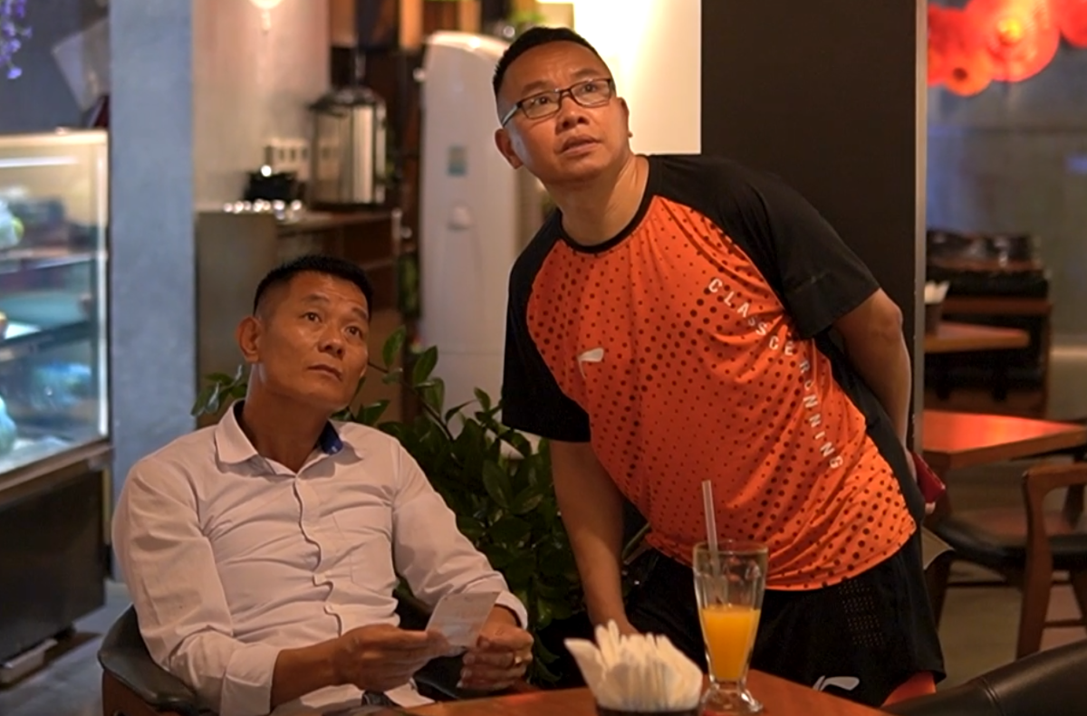 Anh Tô Thành Giang (đứng) đang cùng khách hàng theo dõi kết quả xổ số Keno qua màn hình lớn.