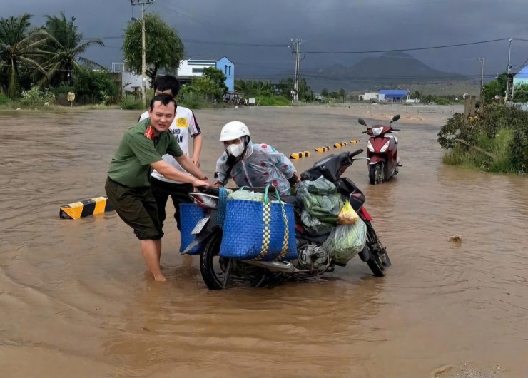 Công an xã Vĩnh Hải hỗ trợ người dân ở quãng đường ngập.