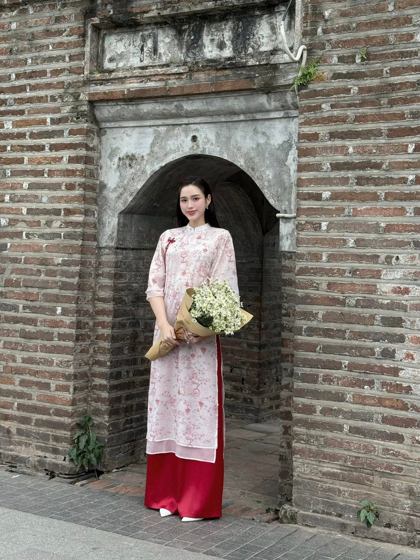 Từ năm ngoái, áo dài 4 tà đã được yêu thích và đến bây giờ, xu hướng này vẫn chưa hạ nhiệt. Hoa hậu Đỗ Thị Hà cũng khéo léo chọn thiết kế 4 tà màu hồng nhạt nhẹ nhàng, nữ tính nhưng không hề đơn điệu nhờ chiếc quần màu hồng đậm làm điểm nhấn.