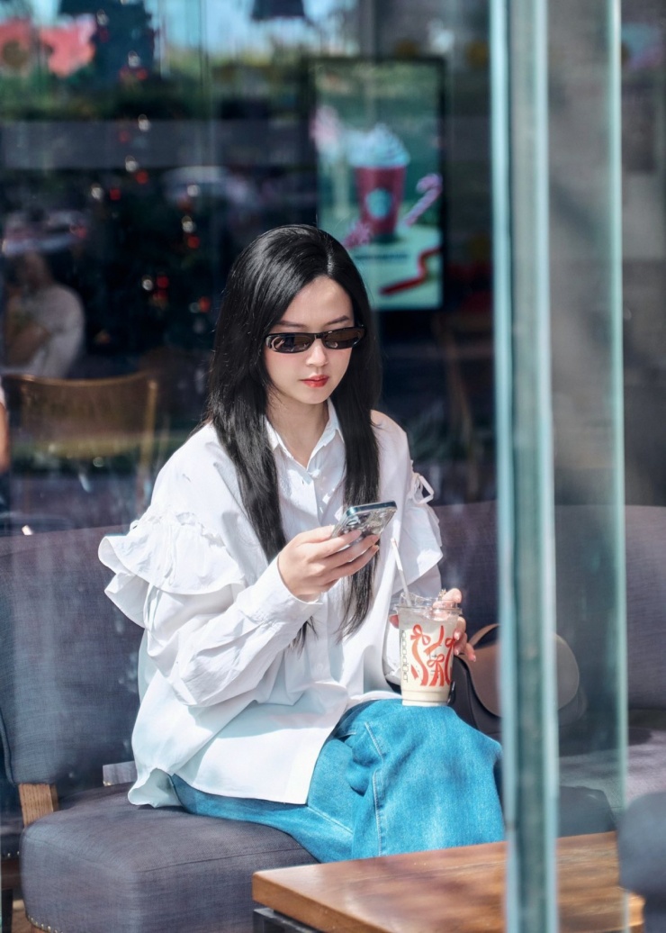 Midu khoe ảnh xuống phố với bộ trang phục gồm sơ mi trắng và quần jeans. Chiếc sơ mi trơn màu được tạo điểm nhấn bằng chi tiết xếp bèo ở tay, tăng vẻ nữ tính cho người mặc.