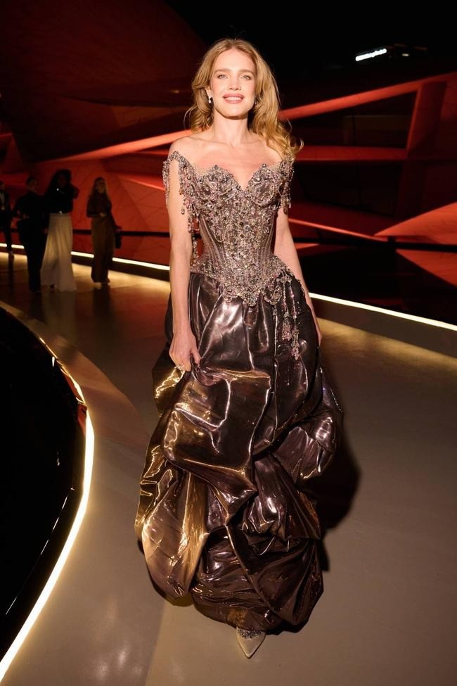 Tới tham dự Lễ trao giải Fashion Trust Arabia 2025, siêu mẫu Natalia Vodianova chọn thiết kế có cấu trúc độc đáo của Christian Lacroix. Thiết kế màu đồng thuộc bộ sưu tập Xuân Hè 1996, xử lý trên lụa ánh kim tạo hiệu ứng như một khối kim loại méo mó.
