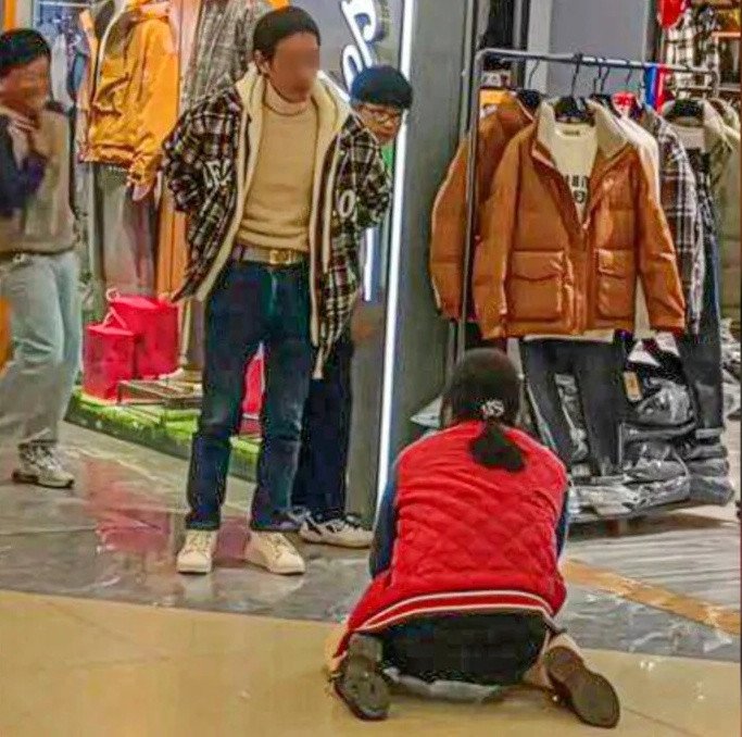 Hình ảnh người vợ cầu xin chồng ở trung tâm thương mại gây xôn xao. Ảnh: SCMP