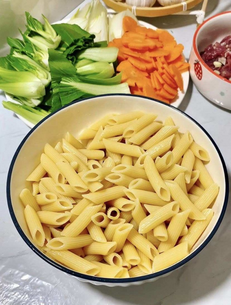 Nui luộc chín, xả qua nước lạnh. Trộn đều 1 thìa dầu mè để không bị dính