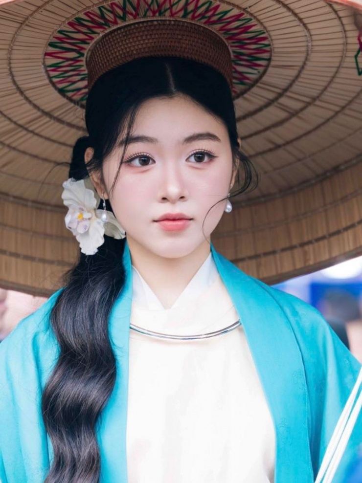 Cô gây chú ý khi diễu hành cổ phục trên phố đi bộ ở Hồ Gươm, hôm 7/12. Lọ Lem phối phụ kiện bông tai ngọc trai cùng vòng cổ bạc và kẹp tóc bông hoa.