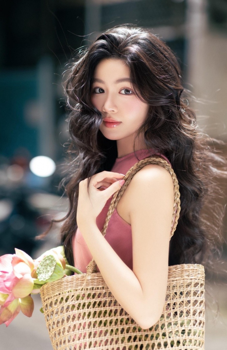 Lọ Lem hóa "nàng thơ" mùa thu khi dạo chợ hoa ở TP HCM. Cô chọn kiểu tóc uốn xoăn bồng bềnh, kết hợp màu son hồng đào.