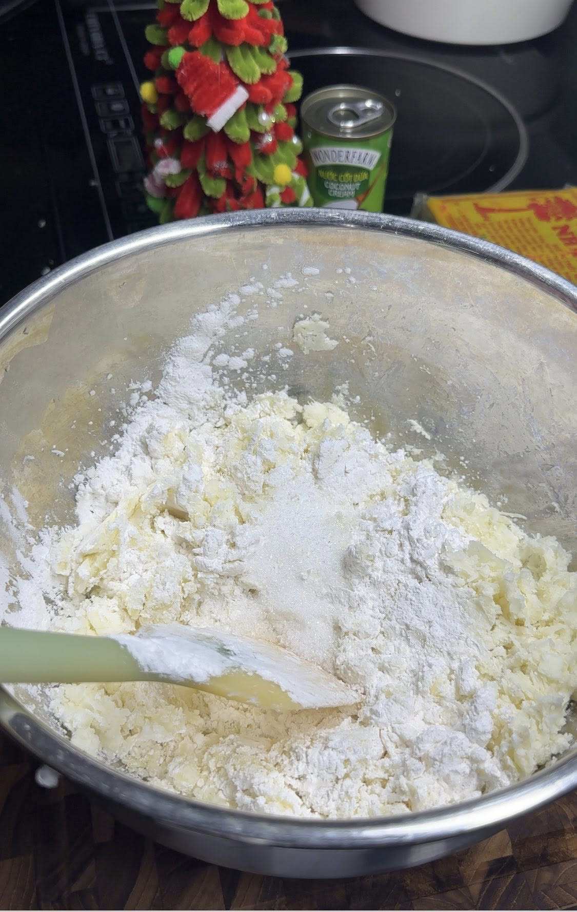 Trộn đều sắn nghiền với nửa bát con bột năng và chút đường, thêm từ từ nước nóng vào nhồi đến khi sắn quyện thành 1 khối.